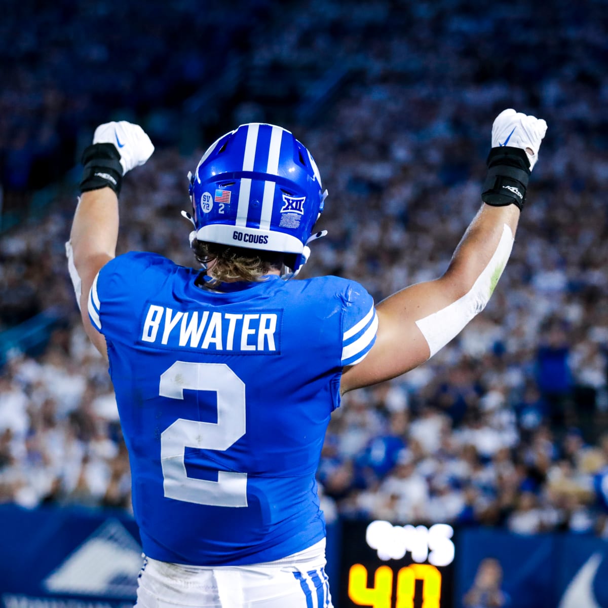 BYU football player celebrating in front of a full stadium